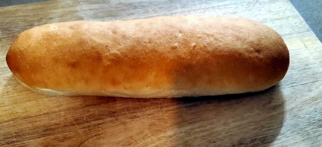 Fresh sourdough sub loaf on a wooden board